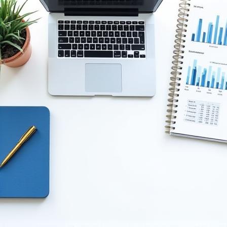 A clean, professional workspace with a laptop, a coffee cup, and printed financial reports